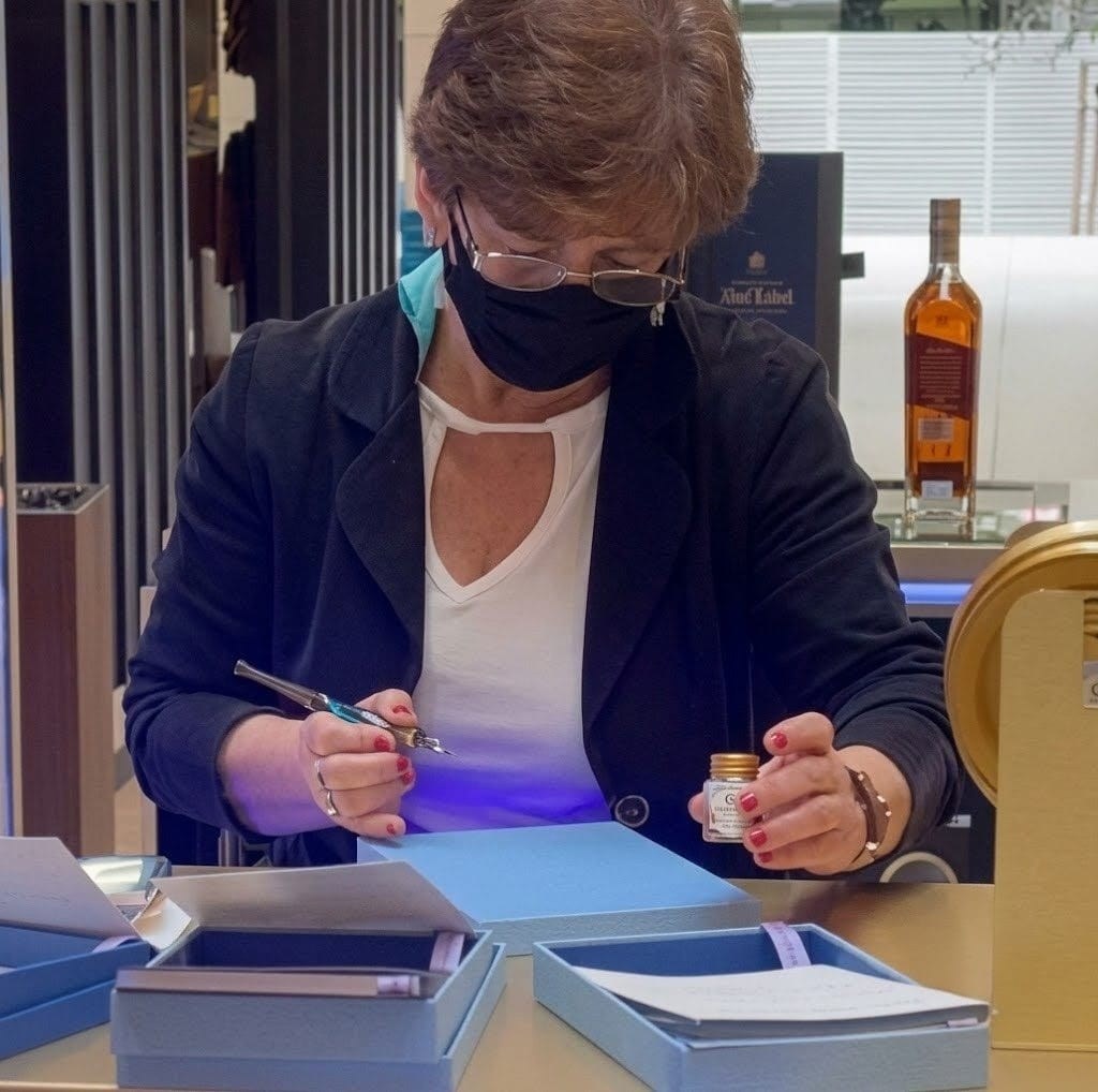 Beth Gauna personalizando um frasco de perfume ao vivo