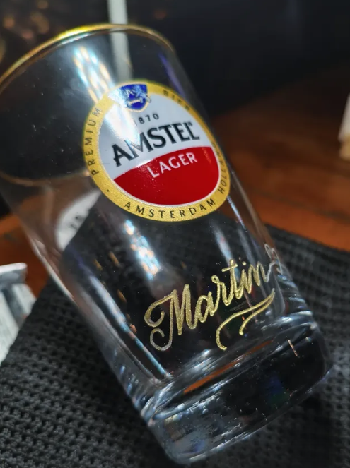 Copo Amstel com assinatura em dourado